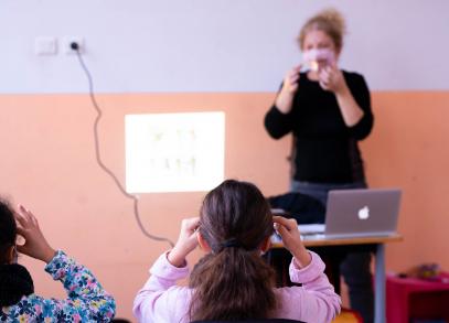Photo représentant une petite fille reproduisant les mêmes gestes qu'une enseignante